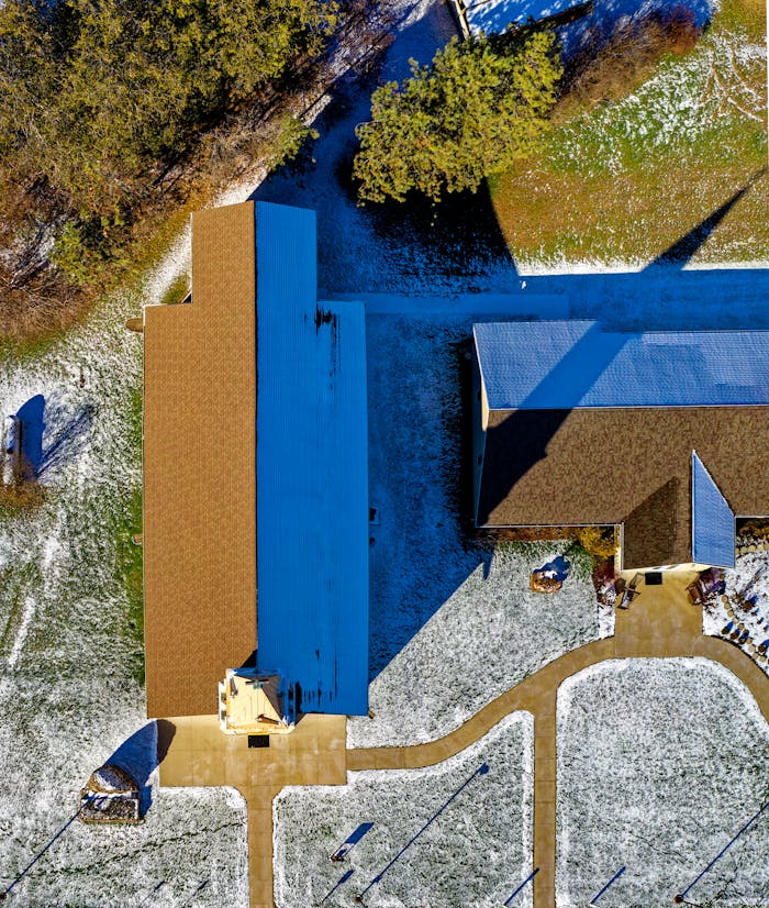 Home Drone shot of a church in Millville, MN, USA, featuring a snow-dusted landscape and clear blue skies.