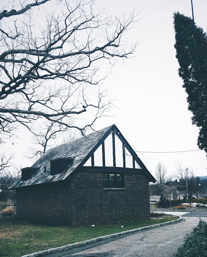 A rustic brick house with a pointed roof set in the picturesque Verona Park, New Jersey, USA.